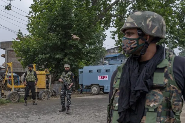 Indian paramilitary soldiers stand guard on a road leading towards the site of a gunfight in Pulwama, south of Srinagar, Indian controlled Kashmir, Wednesday, July 14, 2021. (Photo by Dar Yasin/AP Photo)