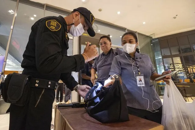 Security guards check a visitor's bag before allowing them into the Siam Paragon Mall in Bangkok, Thailand, Wednesday, October 4, 2023, a day after a teenage boy with a handgun opened fire inside the major shopping mall. (Photo by Wason Wanichakorn/AP Photo)