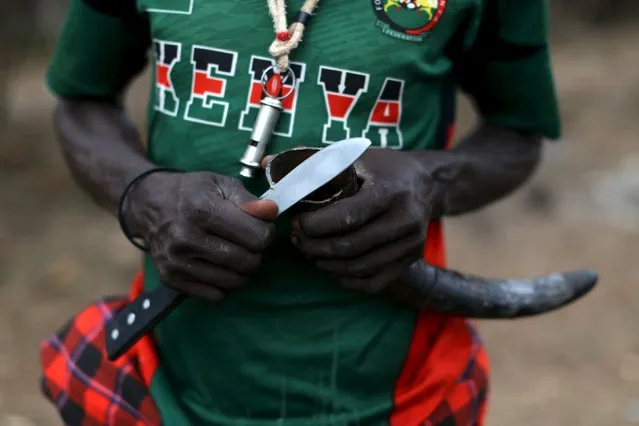 A Pokot man cuts a cow horn that will be used to store an anointment for ceremonies, the day before an initiation ceremony in Baringo County, Kenya, January 19, 2016. (Photo by Siegfried Modola/Reuters)