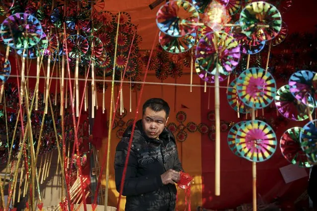 A vendor selling toys and decoration waits for customers inside his booth as the Chinese Lunar New Year, which welcomes the Year of the Monkey, is celebrated at Daguanyuan park, in Beijing, China February 10, 2016. (Photo by Damir Sagolj/Reuters)