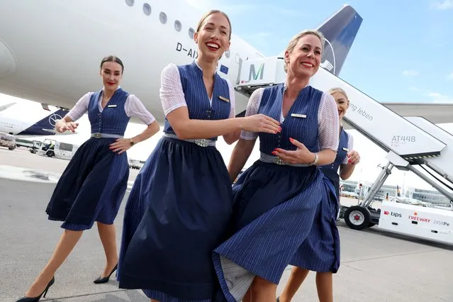 Flight crews of German airliner Lufthansa wear traditional Bavarian folk dress during a photocall to celebrate Oktoberfest at Munich Airport Franz-Joseph-Strauss International on September 15, 2022 in Erding, Germany. Lufthansa cabin crew will dress in the Bavarian traditional costume  “Blaudruck Dirndl“ and “Lederhose” on several international flights during the Oktoberfest who kicks off this coming weekend and will run for three weeks. (Photo by Alexander Hassenstein/Getty Images)