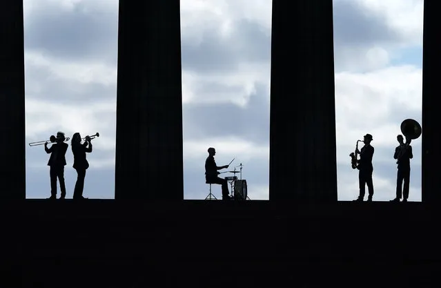 Five members of the band Brass Gumbo play brass instruments in between the columns of the National Monument on Calton Hill in Edinburgh during a photo call for the Edinburgh Jazz and Blues Festival 2021 on Thursday, July 8, 2021. (Photo by Andrew Milligan/PA Images via Getty Images)