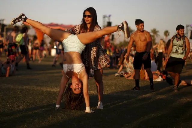 A woman does a handstand as she waits for a band to start playing at the Coachella Valley Music and Arts Festival in Indio, California April 12, 2015. (Photo by Lucy Nicholson/Reuters)