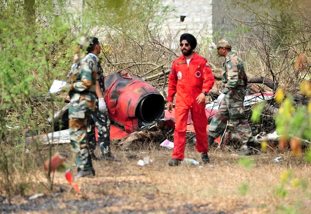 Soldiers stand near the wreckage after two Hawk aircraft of the Surya Kiran Aerobatic Display Team of the Indian Air Force collided in mid-air while rehearsing ahead of Aero India show at the Yelahanka Air Force Station in Bengaluru, India, February 19, 2019. (Photo by Reuters/Stringer)