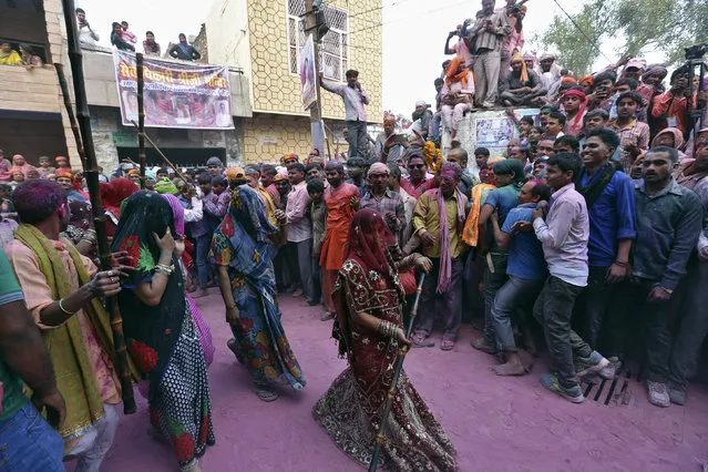 Hindu devotees take part in the religious festival of Lathmar Holi, where women beat the men with sticks, in the town of Barsana in the Uttar Pradesh region of India, March 17, 2016. (Photo by Cathal McNaughton/Reuters)