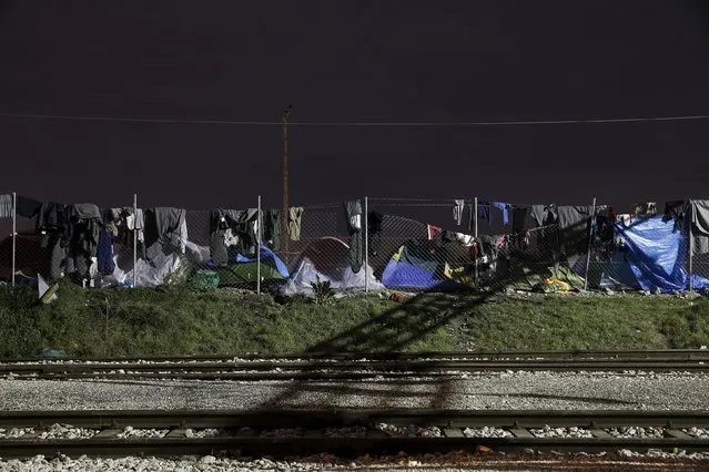 Clothes are seen hanging to dry on a fence next to railway tracks at a makeshift camp at the Greek-Macedonian border, near the village of Idomeni, Greece March 16, 2016. (Photo by Alkis Konstantinidis/Reuters)