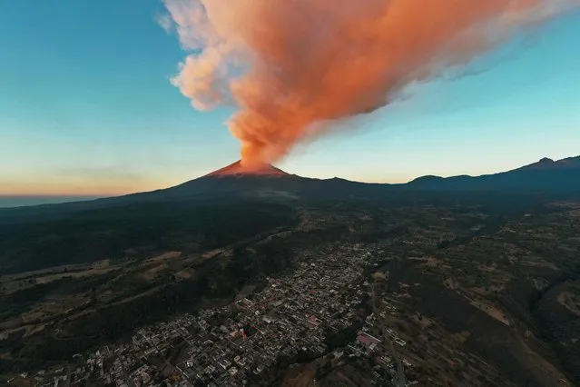 Smoke billows from the Popocatepetl volcano during a celebration day in its honour in Santiago Xalitzintla, Mexico on March 12, 2024. A ceremony in Santiago Xalitzintla was led by Don Antonio Analco Sevilla, 69, who is believed by worshippers to have the ability to talk with the volcano in his dreams. Worshippers annually bring fruits and food as an offering to the volcano for this ceremony. (Photo by José Castañares/AFP Photo) 