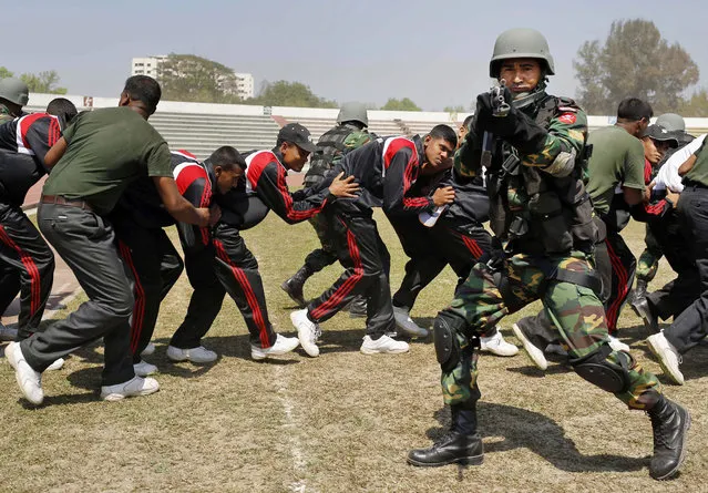 Bangladesh Rapid Action Battalion (RAB) soldiers participate in a mock scene as part of security preparations for the ICC World Twenty20 Cricket tournament at a stadium in Dhaka, Bangladesh, Saturday, March 15, 2014. The first T20 cricket match begins Sunday. (Photo by A. M. Ahad/AP Photo)
