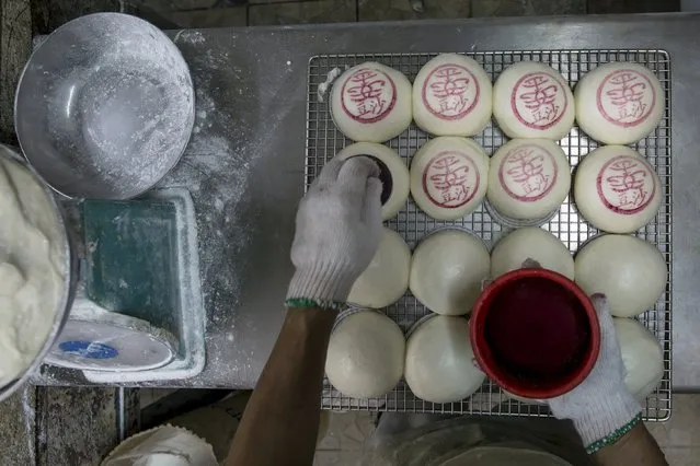 Buns are stamped the Chinese characters “Ping An”, meaning peaceful and safe, inside a bakery, at Hong Kong's Cheung Chau island, China May 17, 2015, ahead of the upcoming Bun Festival on May 25. (Photo by Tyrone Siu/Reuters)