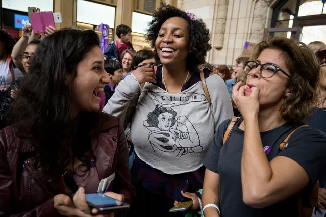 People reacts during a flashmob as part of a nation-wide women's strike for wage parity, on June 14, 2019 at the railway station in Lausanne. Nearly 30 years after staging a first strike, women across Switzerland stage mass demonstrations for for equal pay. Events planned throughout the day range from pram marches, to whistle concerts, to extended lunch breaks and giant picnics, with huge demonstrations planned on June 14 evening in several cities, including in front of the government in Bern. (Photo by Fabrice Coffrini/AFP Photo)