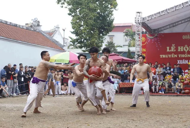 Villagers attend a traditional “ball wrestling” game in Hanoi, Vietnam, Thursday, February 15, 2024. The game, in which players fight to take control of a 25-kilogram (55-pound) wooden ball to put into the opponent's ditch, is organized annually during the spring festival to promote the spirit of martial arts. (Photo by Huy Han/AP Photo)