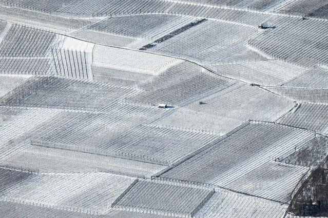 A small house and fields covered in snow are pictured from the Pizzo Di Levico, Alpe Cimbra, Alps Region, northeastern Italy, on December 13, 2021. (Photo by Marco Bertorello/AFP Photo)