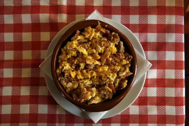 A dish of “Duelos y quebrantos” (griefs and breakings), which Cervantes wrote was Don Quixote's Saturday meal, is pictured at a restaurant in Puerto Lapice, Spain, April 8, 2016. The main ingredients are scrambled eggs, chorizo, ham, bacon and sometimes lamb brains. (Photo by Susana Vera/Reuters)