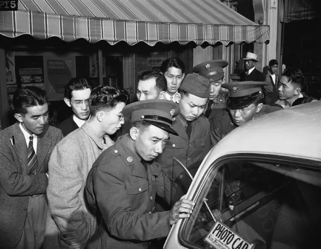 Young Japanese Americans, including several Army selectees, gather around a reporter's car in the Japanese section of San Francisco, December 8, 1941. (Photo by AP Photo)