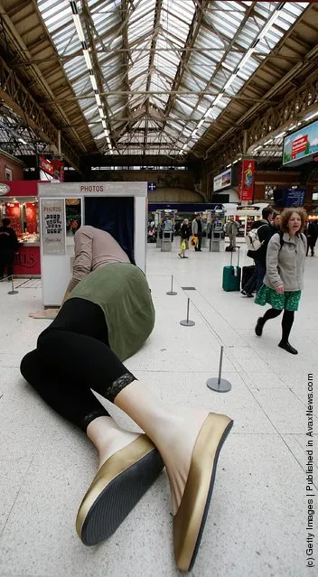 Sculpture of a giant lady with her head stuck in a photo booth