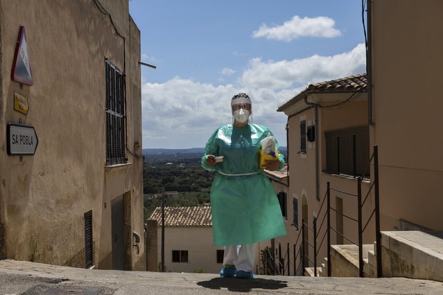 Nurse Pilar Rodríguez arrives at the small town of Buger, barely a thousand inhabitants, at the Spanish Balearic Island of Mallorca, Spain, Friday, April 23, 2021. Pilar Rodríguez, age 49, is one of three nurses in the town of Sa Pobla in the interior of the island to administer shots against COVID-19 there and in nearby villages as Buger. (Photo by Francisco Ubilla/AP Photo)