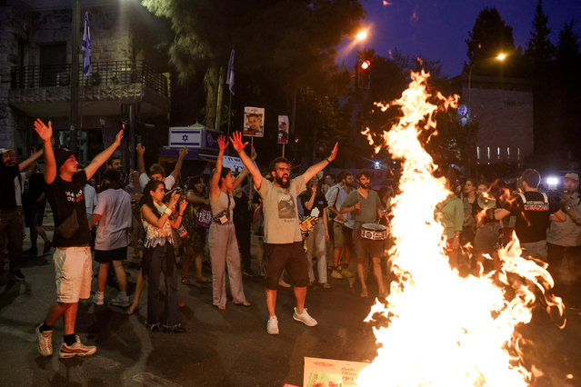 Protesters gesture around a bonfire as protesters attend a rally calling for the immediate release of Israeli hostages held in Gaza since the deadly October 7 attack on Israel by the Palestinian Islamist group Hamas, near Israeli Prime Minister Benjamin Netanyahu's residence, in Jerusalem on April 24, 2024. (Photo by Ronen Zvulun/Reuters)
