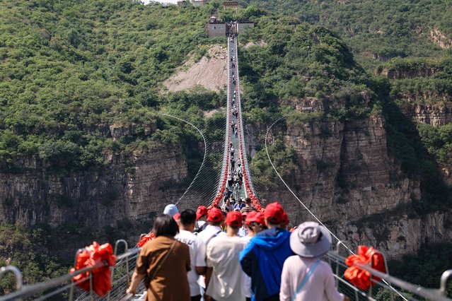 Aerial photo shows tourists walking on a glass suspension bridge in Pingshan County, Shijiazhuang City, north China's Hebei Province, on May 16, 2024. (Photo by Splash News and Pictures)