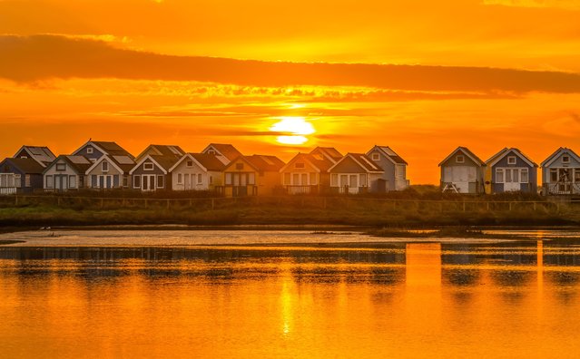 The sunrise above Mudeford beach huts in Dorset, UK with a colourful sky on March 14, 2024. There are about 360 wooden beach huts at Hengistbury Head, Mudeford Spit Sandbank. (Photo by Paul Jacobs/Picture Exclusive)