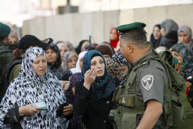 A Palestinian woman argues with an Israeli border policeman as other Palestinians wait to show their identity cards to make their way to attend the third Friday prayer of Ramadan in Jerusalem's al-Aqsa mosque, at an Israeli checkpoint in the West bank city of Bethlehem, July 3, 2015. (Photo by Mussa Qawasma/Reuters)
