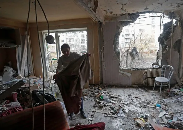 A woman inspects debris inside an apartment of a residential building, which locals said was damaged by recent shelling, in the separatist-controlled town of Horlivka (Gorlovka) in the Donetsk region, Ukraine on March 2, 2022. (Photo by Alexander Ermochenko/Reuters)