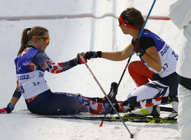 Gold medallist Natalie Wilkie of Team Canada (R) fist bumps Silver medallist Vilde Nilsen of Team Norway after the in the Women's Sprint Free Technique Standing Final on day five of the Beijing 2022 Winter Paralympics at Zhangjiakou National Biathlon Centre on March 09, 2022 in Zhangjiakou, China. (Photo by Gonzalo Fuentes/Reuters)