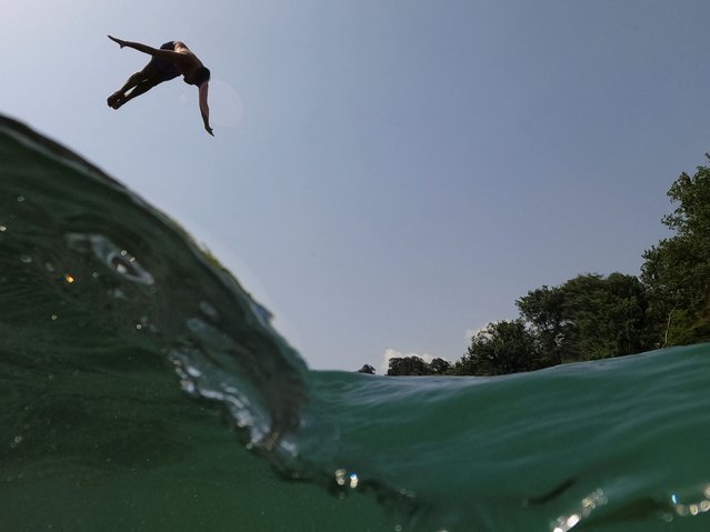 A man jumps into the Drinos river to cool off during the heat wave, near Tepelena, on June 22, 2024. (Photo by Florion Goga/Reuters)