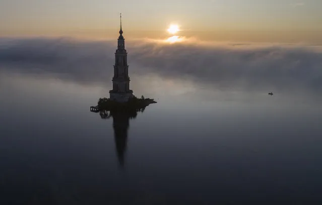 The famous Kalyazin Bell Tower, part of the submerged monastery of St. Nicholas, is seen in the morning fog in the town of Kalyazin located on the Volga River, 180 km (111 miles) north-east of Moscow, Russia, Monday, August 12, 2019. After the construction of the Uglich Dam in 1939 to form the Uglich Reservoir, the old parts of Kalyazin, including several medieval structures, were submerged under the reservoir's waters. (Photo by Dmitri Lovetsky/AP Photo)