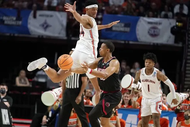 Jacksonville State's Darian Adams (23) passes the ball as Auburn's Dylan Cardwell (44) defends during the first half of a college basketball game in the first round of the NCAA tournament Friday, March 18, 2022, in Greenville, S.C. (Photo by Brynn Anderson/AP Photo)