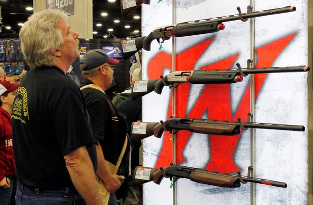 Gun enthusiasts look over Winchester guns at the National Rifle Association's annual meetings and exhibits show in Louisville, Kentucky, May 21, 2016. (Photo by John Sommers II/Reuters)