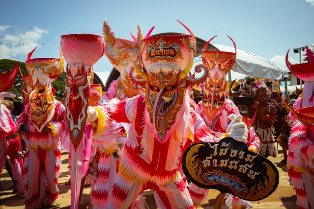 A group of revellers in pink costumes dance on July 09, 2024 in Loei, Thailand. The Phi Ta Khon Festival in Dan Sai, Loei province is a vibrant three-day celebration featuring colorful masked processions, raucous parties, and traditional ghost masks made from dried palm leaves and bamboo sticky rice baskets. Locals dress up in elaborate costumes with exaggerated features, some carrying wooden phalluses as symbols of fertility, while others daub their bodies in mud to represent rice fields. The festival combines elements of Buddhist merit-making, animistic beliefs, and Brahmanistic traditions as the townspeople invite protection from spirits and pray for bountiful rains for the coming farming season. (Photo by Mailee Osten-Tan/Getty Images)