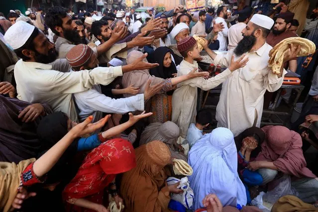 People receive free food during the Muslims fasting month of Ramadan, in Peshawar, Pakistan, 05 April 2022. Muslims around the world celebrate the holy month of Ramadan, by praying during the night time and abstaining from eating, drinking, and sexual acts during the period between sunrise and sunset. Ramadan is the ninth month in the Islamic calendar and it is believed that the revelation of the first verse in Koran was during its last 10 nights. (Photo by Arshad Arbab/EPA/EFE)