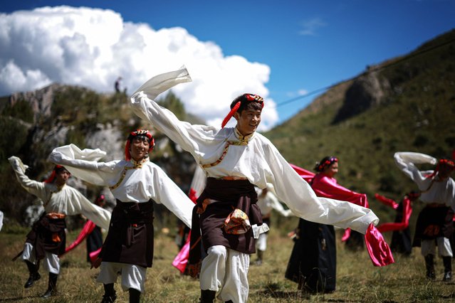 This photo taken on August 20, 2024 shows Tibetan performers dancing to welcome tourists in Yushu, in northwestern China's Qinghai province. (Photo by AFP Photo/China Stringer Network)