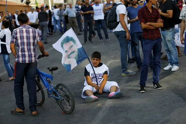 A demonstrator holds a portrait of Kurdistan Workers Party (PKK)'s jailed leader Abdullah Ocalan during a march in solidarity with him in Diyarbakir, Turkey, August 1, 2015. (Photo by Umit Bektas/Reuters)