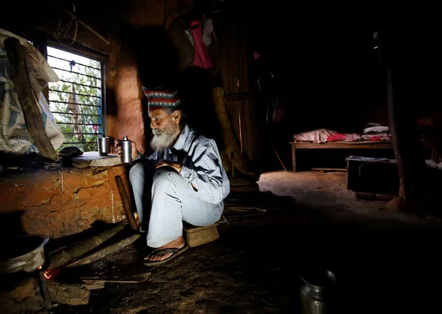 Durga Kami, 68, who is studying in the tenth grade at Shree Kala Bhairab Higher Secondary School, drinks tea as he prepares dinner at his one-room house in Syangja, Nepal, June 4, 2016. (Photo by Navesh Chitrakar/Reuters)