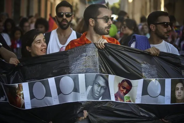 People hold a banner with the portraits of the victims of the Orlando massacre during the 17th Lisbon gay pride parade against the discrimination of lesbian, gay, bisexual, and transgender (LGBT) people, in Lisbon, Portugal, 18 June 2016. (Photo by Mario Cruz/EPA)