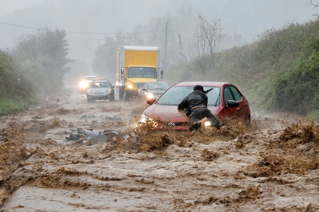 A local resident helps free a car that became stranded in a stretch of flooding road as Tropical Storm Helene strikes, on the outskirts of Boone, North Carolina, U.S. September 27, 2024. (Photo by Jonathan Drake/Reuters)