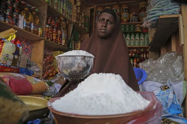 A shopkeeper sells wheat flour in the Hamar-Weyne market in the capital Mogadishu, Somalia Thursday, May 26, 2022. Families across Africa are paying about 45% more for wheat flour as Russia's war in Ukraine blocks exports from the Black Sea. Some countries like Somalia get more than 90% of their wheat from Russia and Ukraine. That's forcing many people to substitute wheat for other grains. But the United Nations is warning that the price hikes are coming as many parts of Africa are facing drought and hunger. (Photo by Farah Abdi Warsameh/AP Photo)