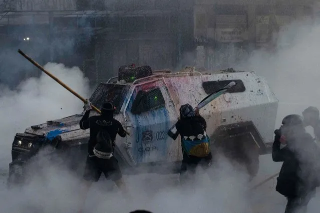 Demonstrators clash with riot police near to La Moneda Presidential Palace on October 18, 2021 in Santiago, Chile. On October 18, 2019, an increase in the subway fare triggered demonstrations claiming for measures to reduce social and economic inequality. The protests turned out into a nationwide social unrest that paralyzed the country for nearly six months. Protestors held massive rallies with up to 1.2 million people requesting President Sebastian Piñera's resignation and a wide range of issues including health care, pension system, public education, social mobility, privatization of water services and corruption. After holding a referendum in October 2020, a national assembly is now working to rewrite the Pinochet-era constitution as a response to social demands. (Photo by Claudio Santana/Getty Images)