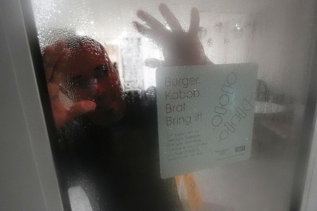 Alex Martinez, of Tampa, Fla., looks out the window of the hotel he's taking shelter in while riding out Hurricane Milton, Wednesday, October 9, 2024, in Tampa, Fla. (Photo by Julio Cortez/AP Photo)