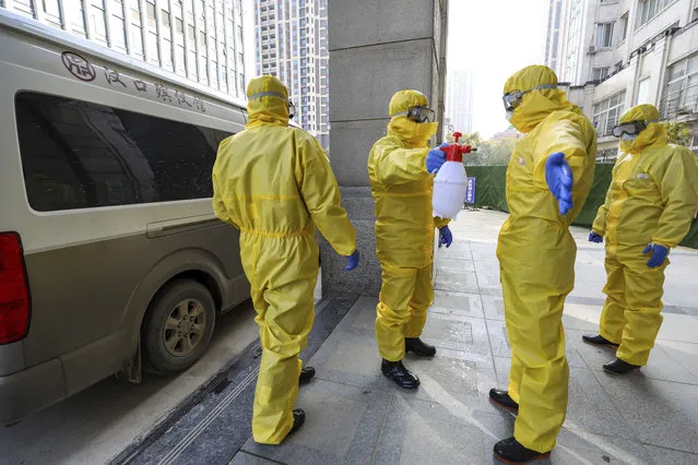 Funeral workers disinfect themselves after handling a virus victim in Wuhan in central China's Hubei Province, Thursday, January 30, 2020. China counted 170 deaths from a new virus Thursday and more countries reported infections, including some spread locally, as foreign evacuees from China's worst-hit region returned home to medical observation and even isolation. (Photo by Chinatopix via AP Photo)