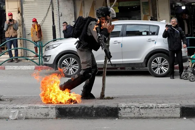 An Israeli border policeman is on fire as he is hit with a molotov cocktail thrown by Palestinian demonstrators during a protest against the U.S. President Donald Trump's Middle East peace plan, in Hebron in the Israeli-occupied West Bank on February 3, 2020. (Photo by Mussa Qawasma/Reuters)