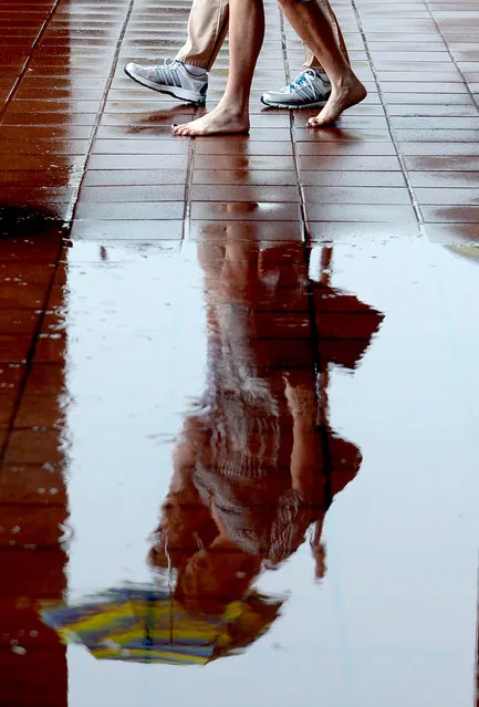 In this Wednesday, July 8, 2015 photo, Suzanne Myers, front, and Michelle Parsons walk near a puddle while shopping at the Twenty Ninth Street Mall in Boulder, Colorado. (Photo by Cliff Grassmick/The Daily Camera via AP Photo)