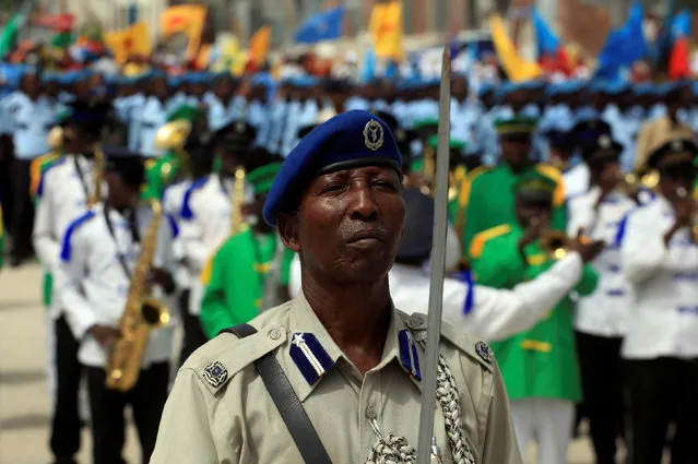 A Somali policeman leads a parade during the Independence day celebrations outside the ruins of the former Parliament buildings in Mogadishu, Somalia July 1, 2016. (Photo by Ismail Taxta/Reuters)