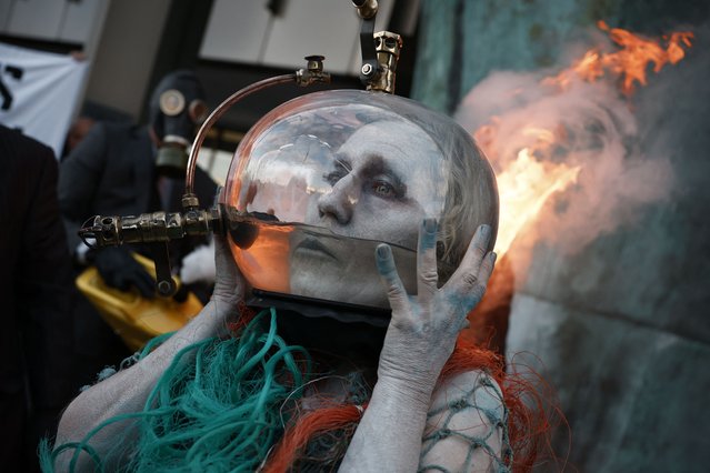 Activists from climate action group Ocean Rebellion take part in a performance using liquid natural gas beside the International Memorial to Seafarers on the Albert Embankment in London on October 4, 2024. According to their press release, their aim is to expose how many companies are “hoodwinking International Maritime Organisation (IMO) delegates by falsely claiming Liquid Natural Gas is a green fuel”" and to “expose how the IMO is doing nothing to stop LNG becoming the fossil fuel of choice for shipping”. (Photo by Benjamin Cremel/AFP Photo)