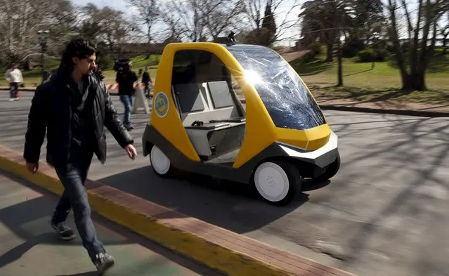 A man walks next to a prototype of an autonomous electric vehicle during its presentation in Buenos Aires, August 19, 2015. The autonomous vehicle, the first of its kind developed in Argentina, is able to fulfill the main functions of mobility of a traditional car but autonomously through the use of artificial intelligence that enables it to detect their surroundings and move without human intervention. (Photo by Marcos Brindicci/Reuters)