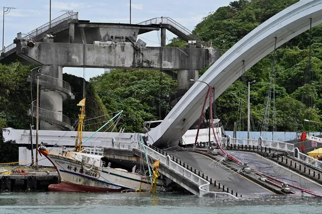 A fishing boat is pictured after it was crushed when a bridge collapsed in the Nanfangao fish harbour in Suao township on October 1, 2019. The bridge collapsed in northeastern Taiwan on October 1 injuring at least 14 people as it smashed down onto fishing vessels moored underneath and sent a petrol tanker plummeting into the water. (Photo by Sam Yeh/AFP Photo)