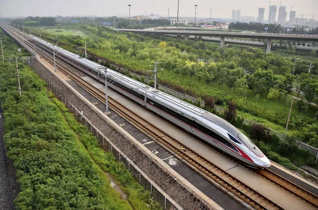 In this August 21, 2017 photo released by China's Xinhua News Agency, a Fuxing bullet train, China's latest high-speed train, arrives at a train station in northern China's Tianjin Municipality. China is relaunching the world's fastest bullet trains in September 2017, running at 350 kilometers (217 miles) per hour. China first ran trains at 350 kilometers per hour in August 2008, but cut speeds back to 250-300 kilometers per hour in 2011 following a two-train collision near the city of Wenzhou that killed 40 people and injured 191. (Photo by Yang Baosen/Xinhua via AP Photo)
