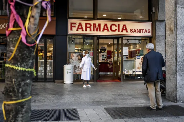 A pharmacist wears a mask as she speaks to a man keeping his distance, outside a pharmacy in Milan, Italy, Wednesday, March 11, 2020. Expressing alarm both about mounting infections and slow government responses, the World Health Organization declared Wednesday that the global coronavirus crisis is now a pandemic but also said it's not too late for countries to act. For most people, the new coronavirus causes only mild or moderate symptoms, such as fever and cough. For some, especially older adults and people with existing health problems, it can cause more severe illness, including pneumonia. (Photo by Claudio Furlan/LaPresse via AP Photo)