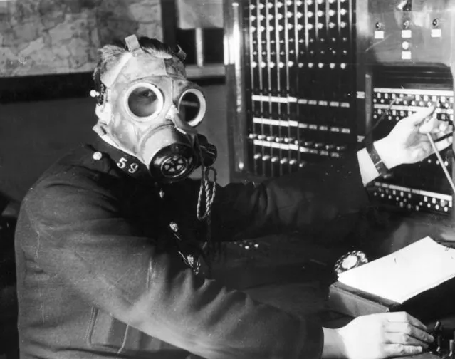A Chesterfield Borough Police telephone operator tests a gasmask with built in earpiece and microphone. The telephone service is considered one of the most important links in the coordination of ARP operations and must remain operational during air raids, 12th April 1939. (Photo by Fox Photos/Hulton Archive/Getty Images)